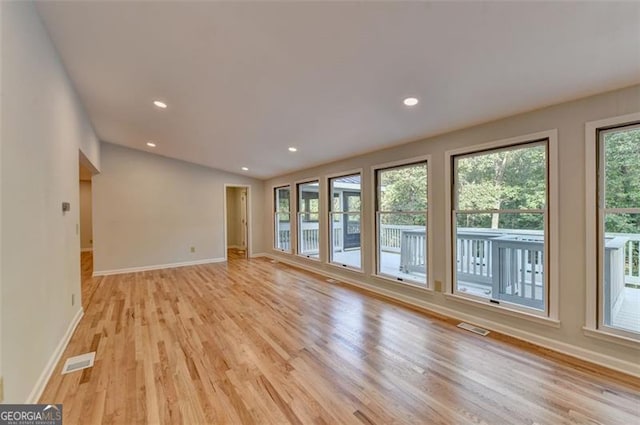 unfurnished living room with light hardwood / wood-style flooring and lofted ceiling