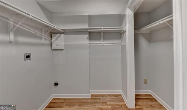 clothes washing area with wood-type flooring and hookup for an electric dryer