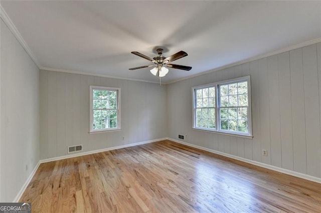 empty room with ceiling fan, light hardwood / wood-style flooring, and ornamental molding