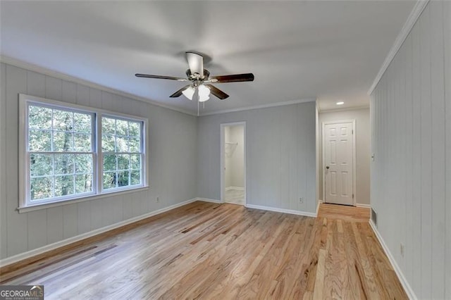 empty room featuring ceiling fan, ornamental molding, and light hardwood / wood-style flooring