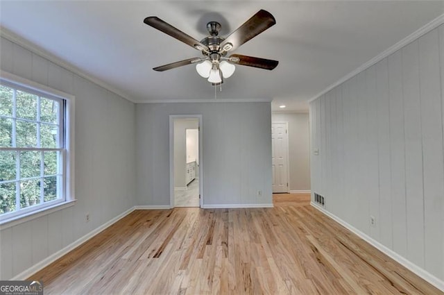 spare room with crown molding, ceiling fan, a healthy amount of sunlight, and light hardwood / wood-style floors