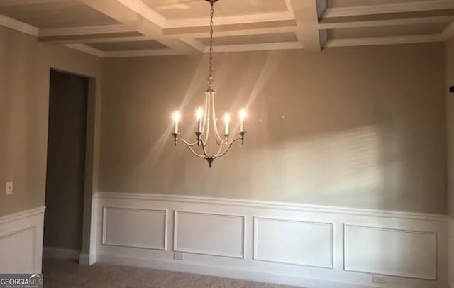 interior space with carpet flooring, beamed ceiling, coffered ceiling, and an inviting chandelier