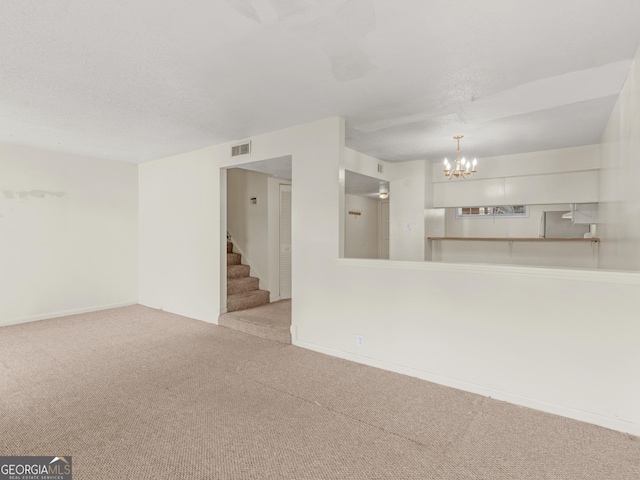 unfurnished living room with a notable chandelier and light carpet