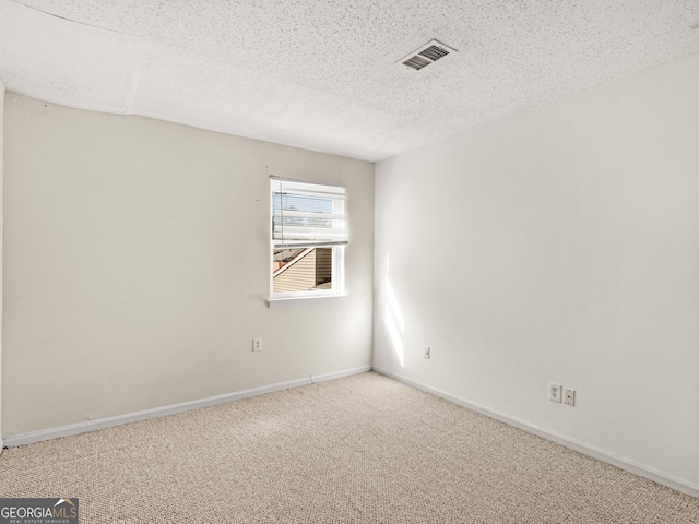 empty room with carpet floors and a textured ceiling