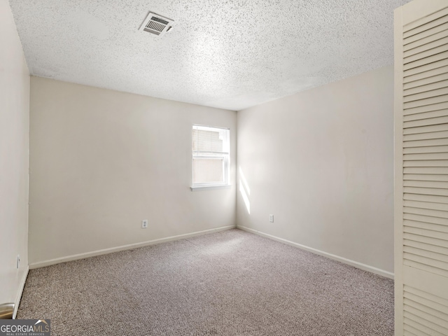 carpeted spare room featuring a textured ceiling