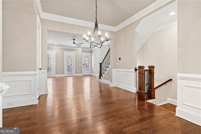 foyer featuring hardwood / wood-style floors, ceiling fan with notable chandelier, and ornamental molding