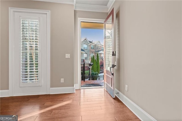 doorway to outside featuring crown molding, hardwood / wood-style floors, and a healthy amount of sunlight