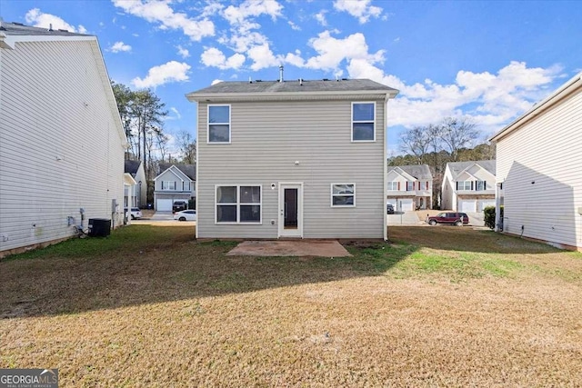 rear view of property featuring a patio area, a yard, and central AC