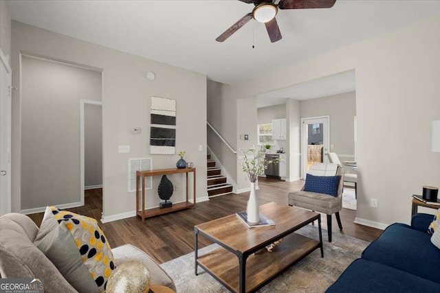 living room with dark hardwood / wood-style flooring and ceiling fan