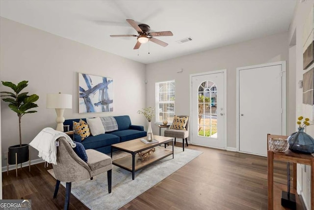 living room featuring ceiling fan and dark hardwood / wood-style flooring