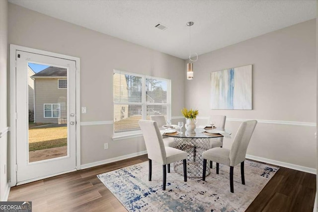 dining area with a healthy amount of sunlight and dark wood-type flooring