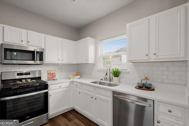 kitchen featuring dark hardwood / wood-style floors, sink, white cabinetry, and stainless steel appliances