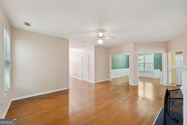 unfurnished living room featuring visible vents, plenty of natural light, light wood-style flooring, and ceiling fan