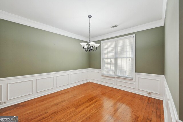 bedroom with light hardwood / wood-style flooring, an inviting chandelier, and ornamental molding