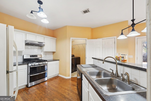 kitchen with visible vents, dark countertops, under cabinet range hood, double oven range, and a sink