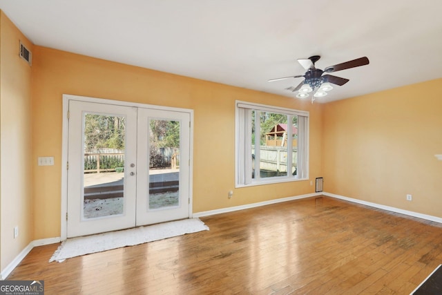 spare room with baseboards, visible vents, wood finished floors, and french doors