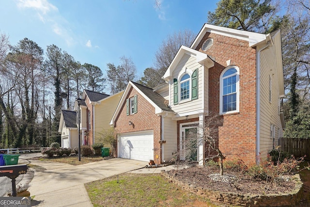 traditional home featuring a garage, driveway, and brick siding