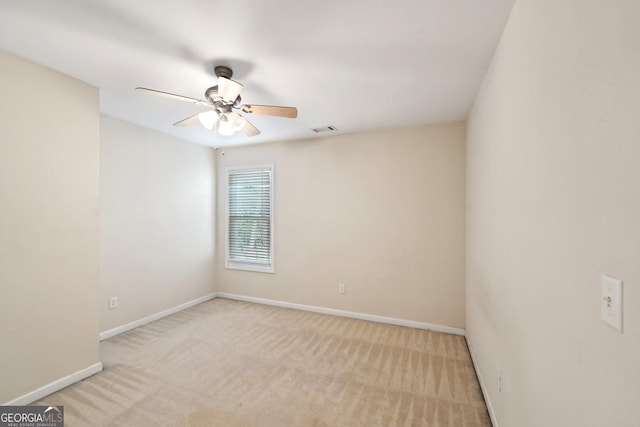 spare room featuring light carpet, baseboards, visible vents, and a ceiling fan