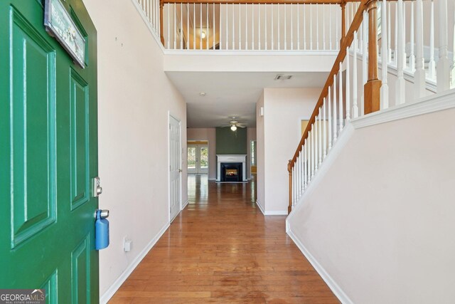 foyer with light wood-type flooring and a towering ceiling