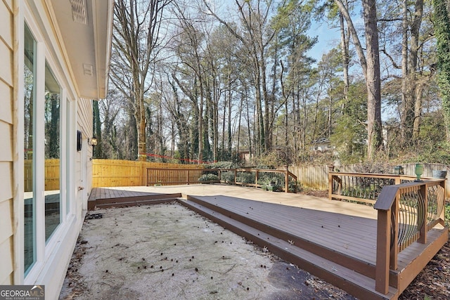 wooden terrace with a patio and a fenced backyard