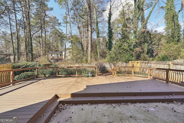 wooden terrace with a fenced backyard