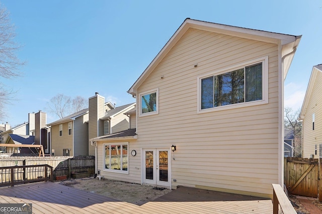 rear view of property with a deck and fence