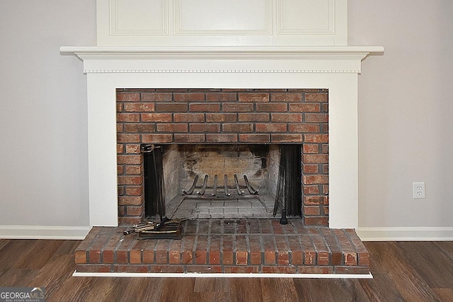 room details with wood-type flooring and a brick fireplace