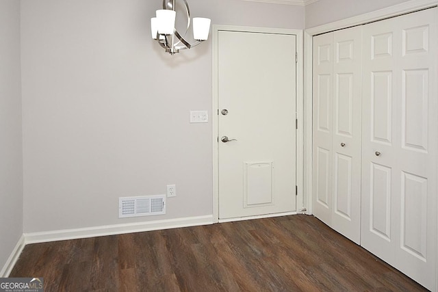 interior space featuring dark wood-type flooring and an inviting chandelier