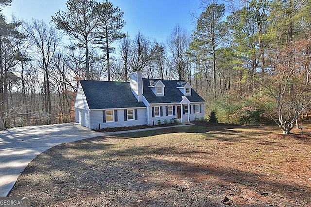 cape cod-style house featuring a front lawn and a garage