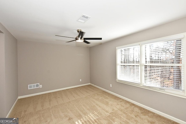 carpeted empty room featuring a wealth of natural light and ceiling fan