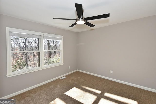 carpeted spare room featuring ceiling fan