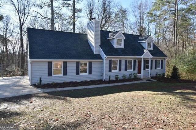 cape cod-style house with a front yard