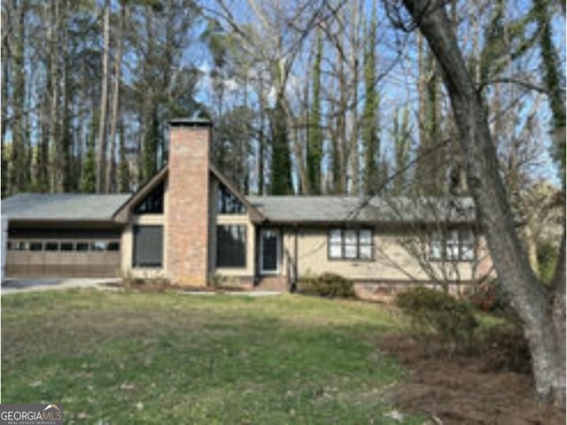 view of front of property featuring a garage and a front lawn