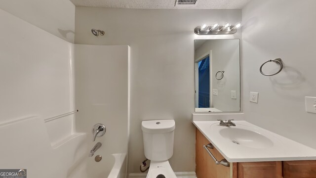 full bathroom featuring a textured ceiling, vanity,  shower combination, and toilet