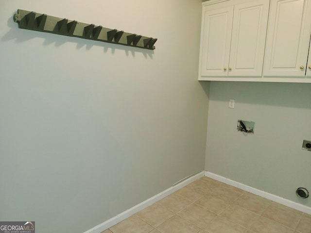 washroom with cabinets, electric dryer hookup, and light tile patterned flooring