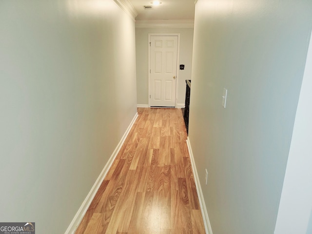 hall with light hardwood / wood-style flooring and ornamental molding