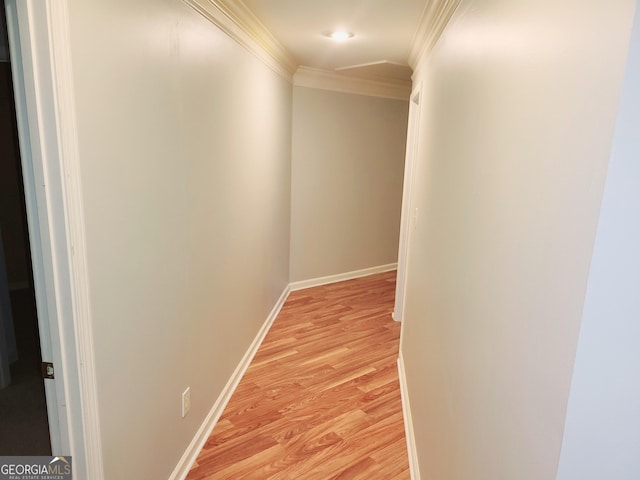 corridor with light hardwood / wood-style floors and crown molding