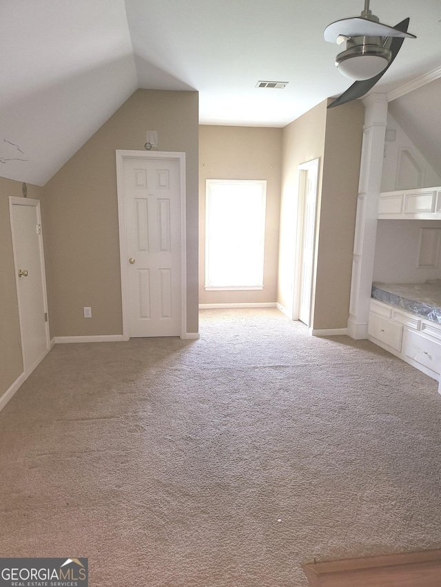 additional living space featuring lofted ceiling and light carpet