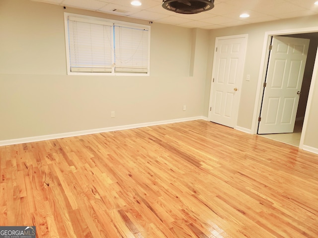 empty room with light wood-type flooring and a paneled ceiling