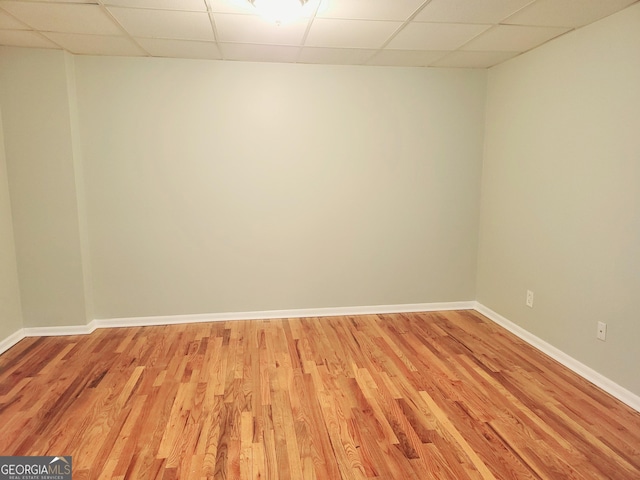 spare room with light hardwood / wood-style flooring and a drop ceiling