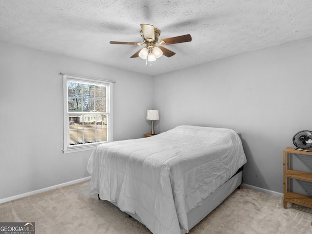 carpeted bedroom with ceiling fan and a textured ceiling