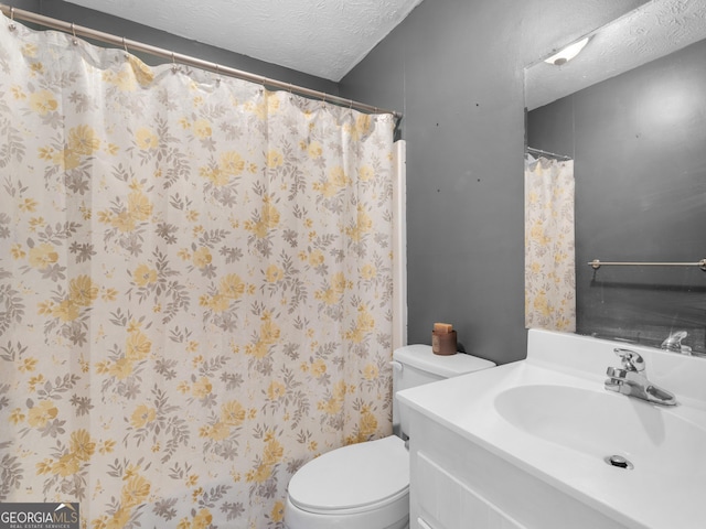 bathroom with vanity, toilet, and a textured ceiling