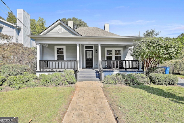 bungalow featuring covered porch and a front lawn