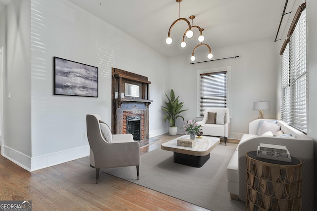 living room featuring a fireplace, hardwood / wood-style floors, and a chandelier