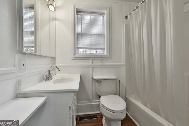 full bathroom featuring shower / tub combo, vanity, toilet, and a wealth of natural light