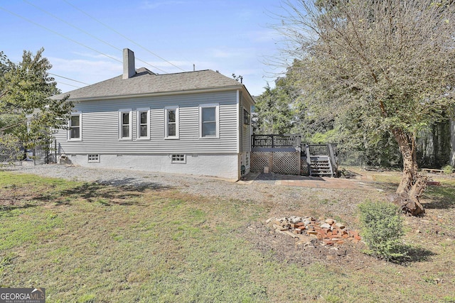 view of property exterior with a lawn and a wooden deck