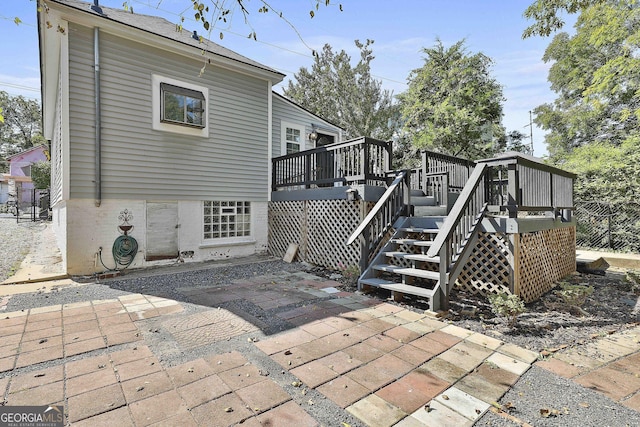 rear view of property with a wooden deck and a patio