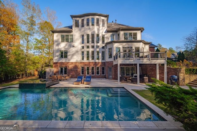 back of property featuring a balcony and a patio area