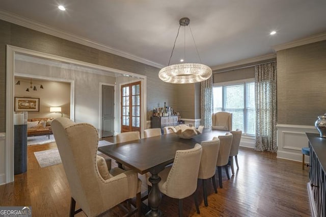 dining area with dark hardwood / wood-style flooring, a notable chandelier, and ornamental molding