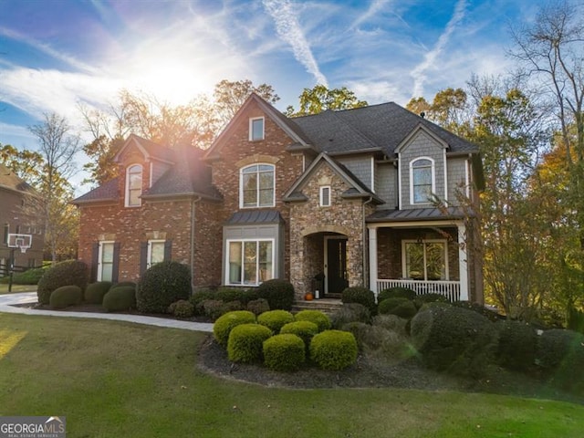 view of front of house featuring covered porch and a front lawn